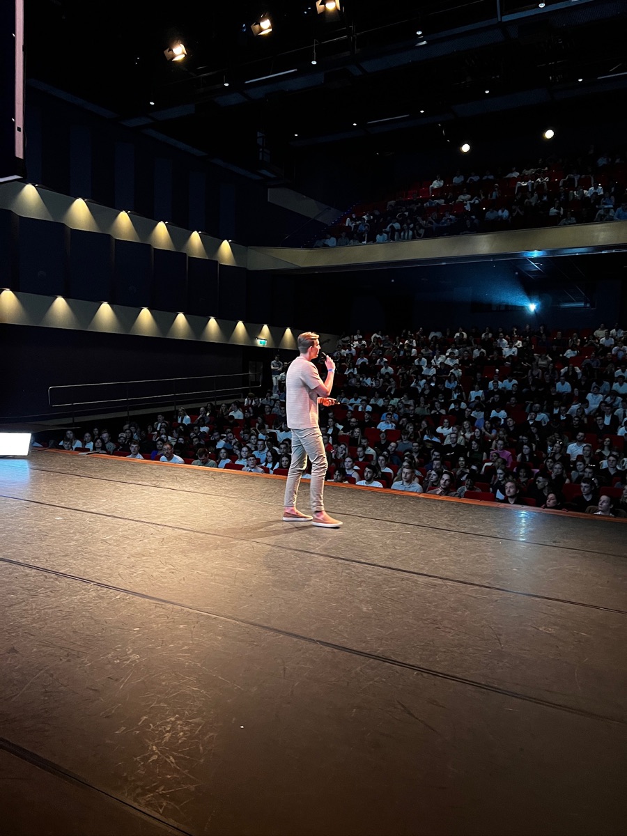 Daan op het podium voor een volle zaal